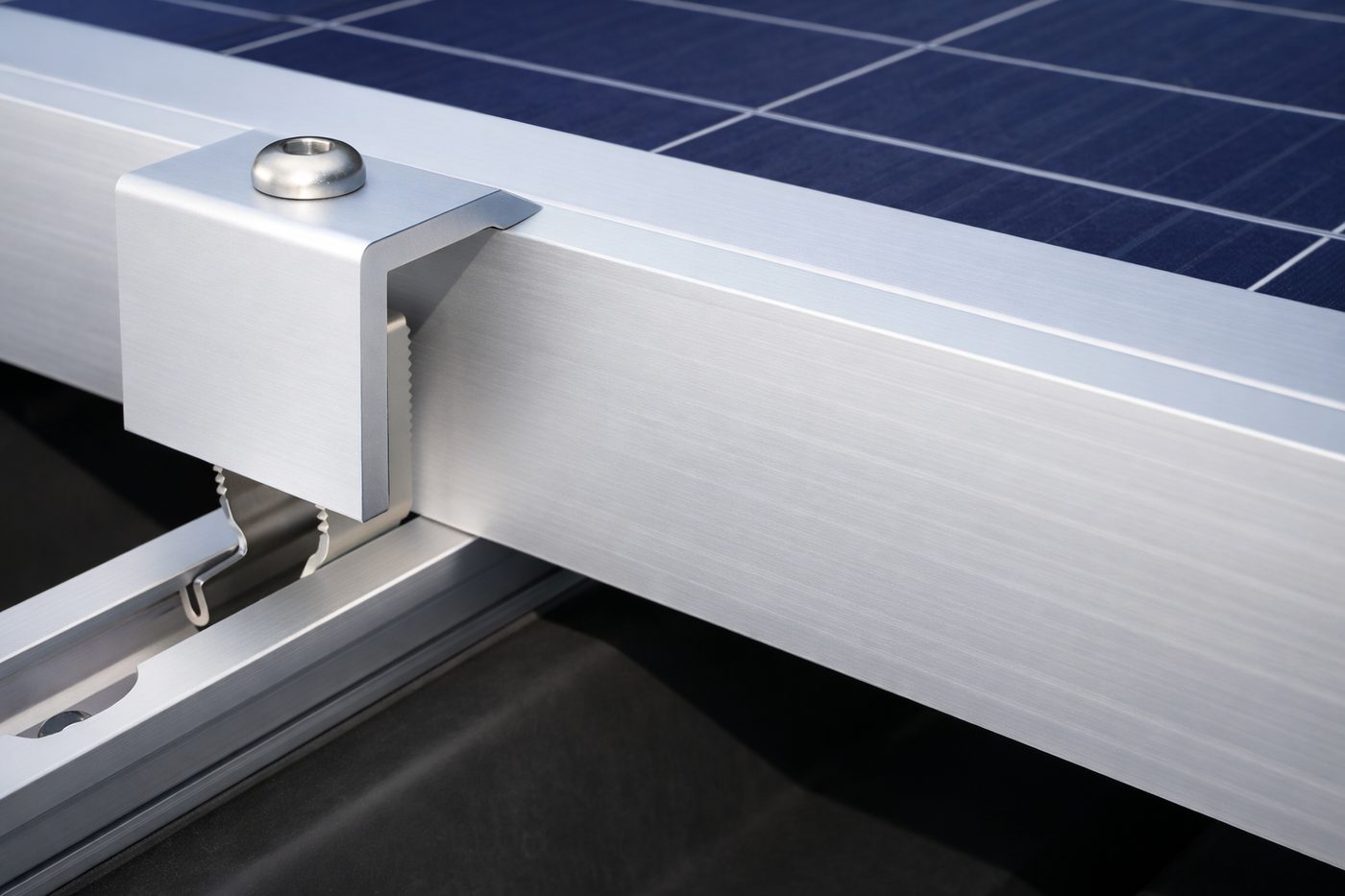 Close-up of a mounting clamp holding a solar panel to its rail
