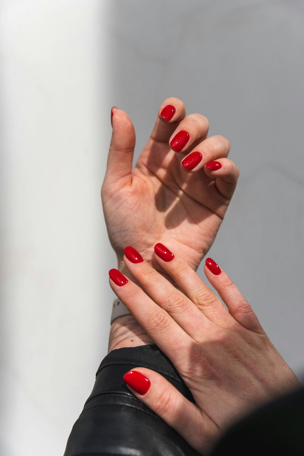 Hands with short, glossy red gel nails