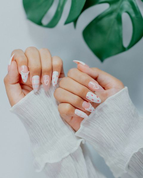 Pearly white almond nails with tiny pink hearts