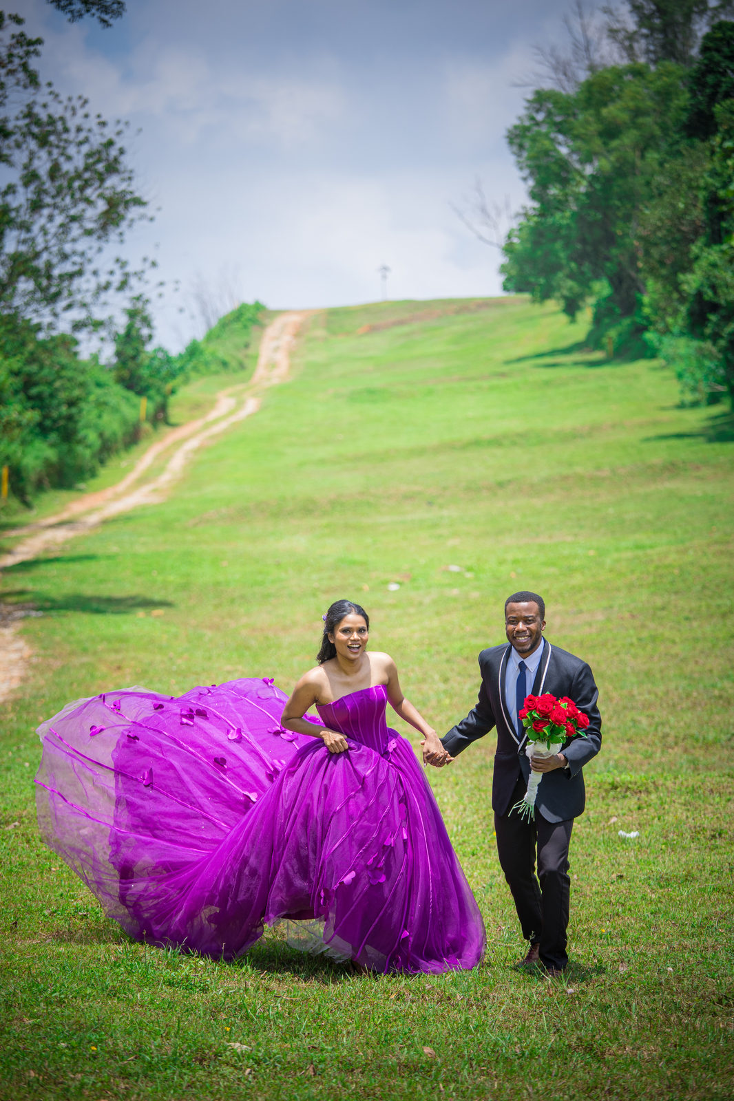 Aghalya and Munshya walking hand in hand down a green hill