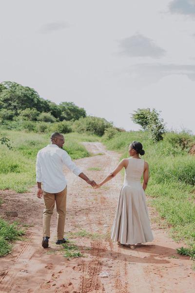 Walking hand in hand down a red-earth path