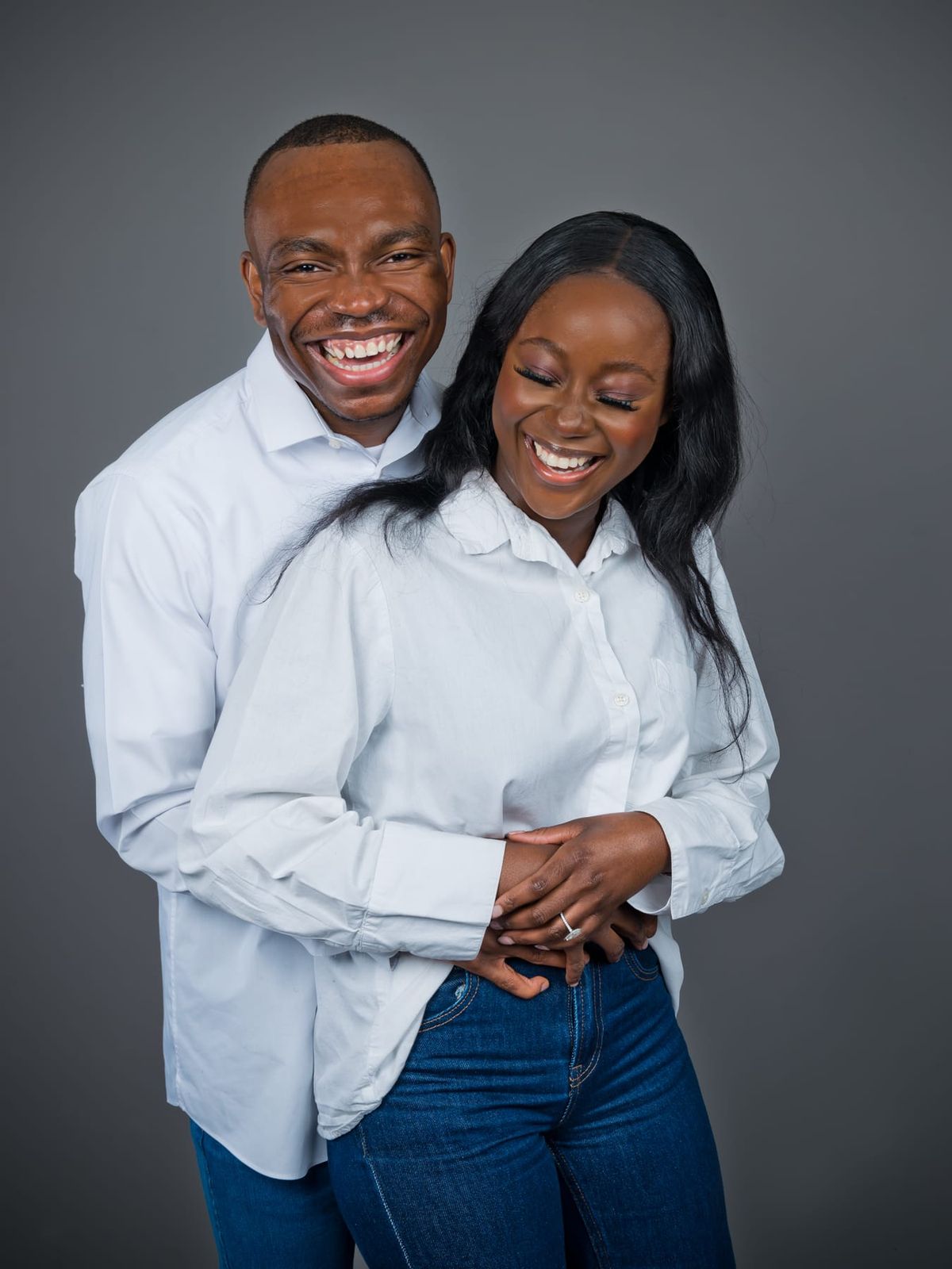 Davidson hugging Makanaka from behind, both in white shirts and laughing