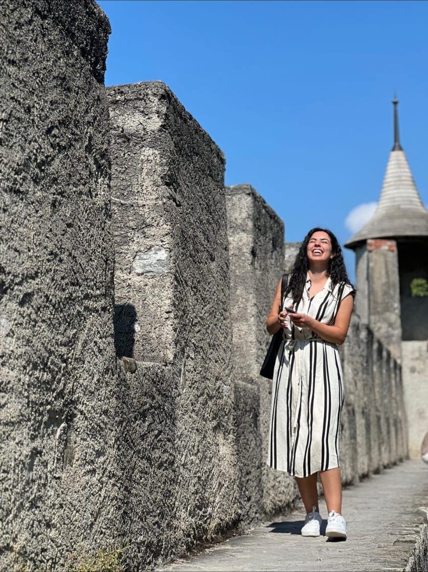 Yasmin laughing on an old stone castle wall